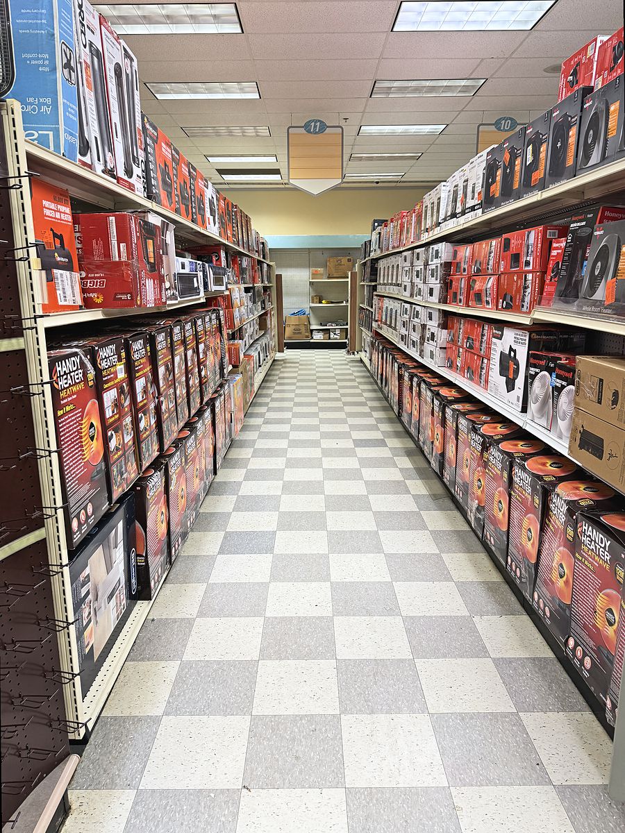 An aisle at Middletown Home Outlet stocked shelf to shelf with boxed heaters, fans and household goods